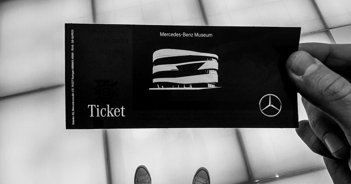 A person holding up a ticket in front of a window