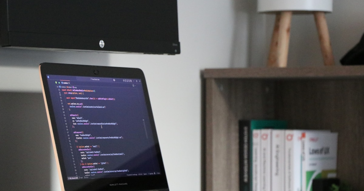Laptop displaying code on a desk