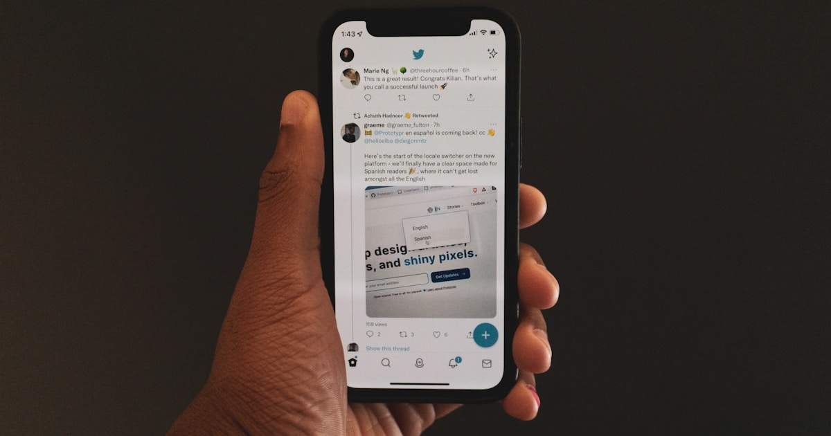 A hand holding a phone with a shared link preview
